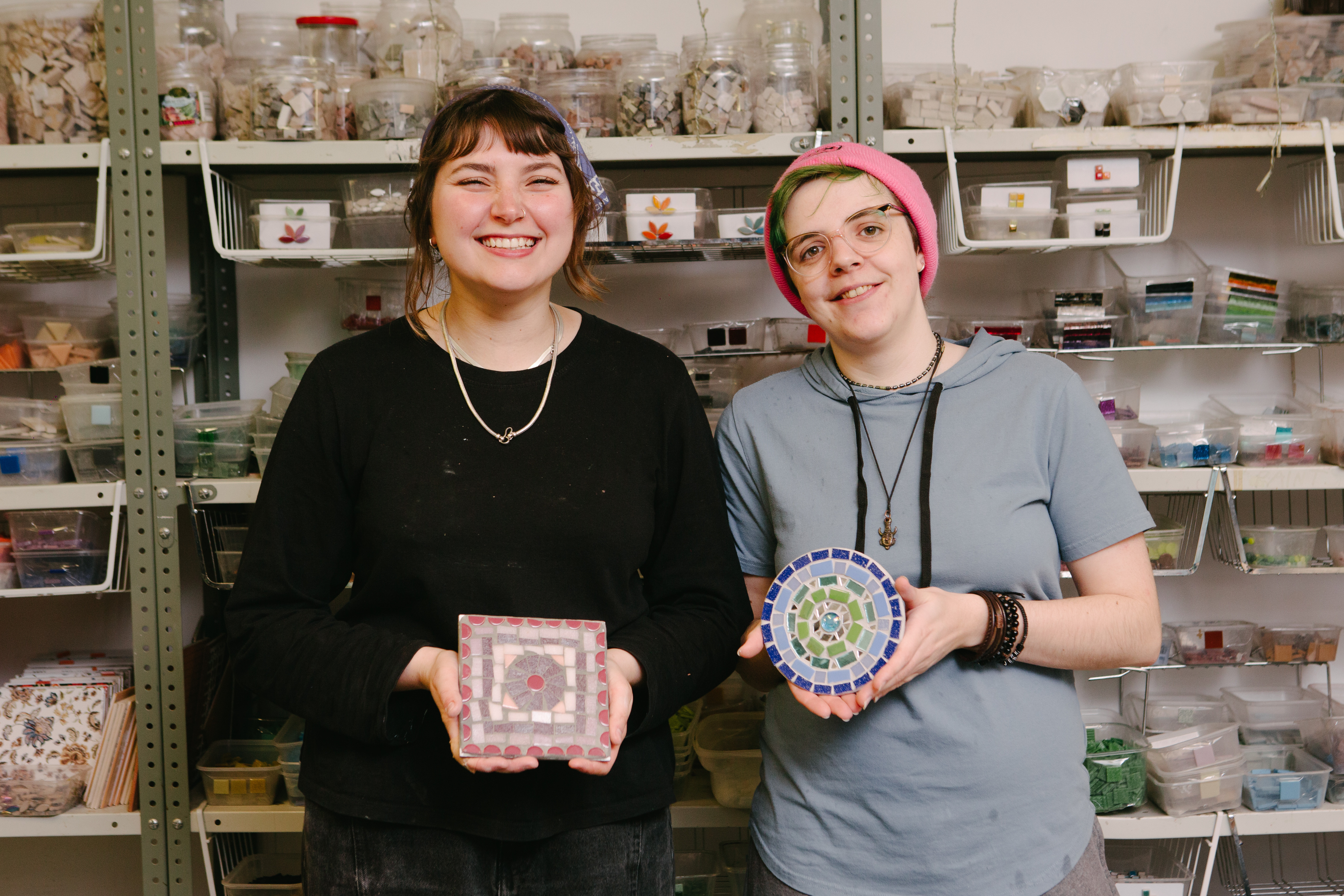 Two people smiling holding ceramic creation
